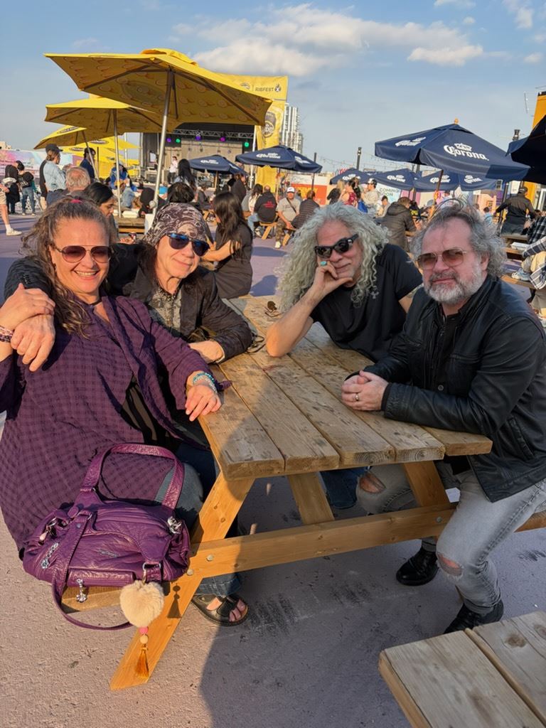 Band members relaxing together at a sunny patio