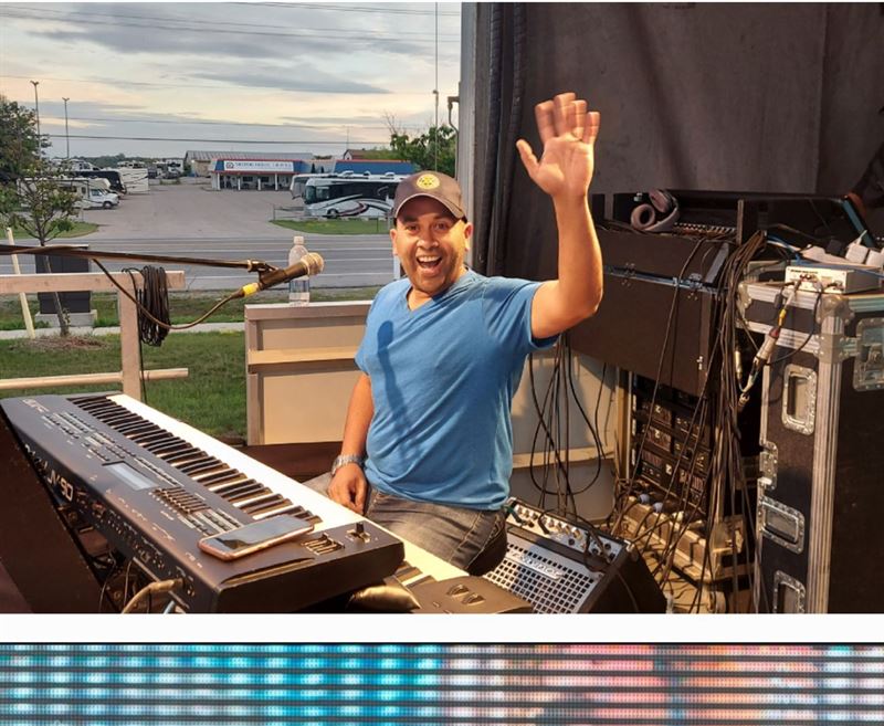 Keyboard player waving from the stage during soundcheck